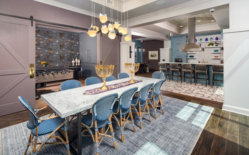 dining table with chairs next to clubhouse kitchen